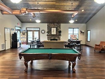 a pool table sits in the middle of a room with a fireplace in the background